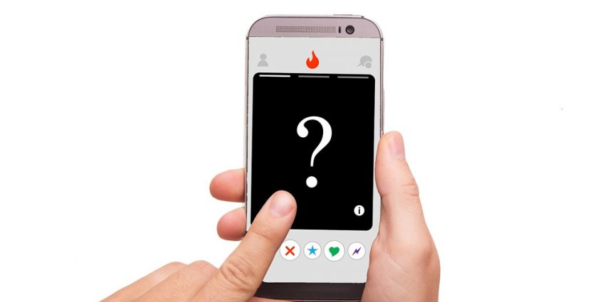 Mãos segurando um telemovél com a aplicação tinder e um sinal de interrogação na tela