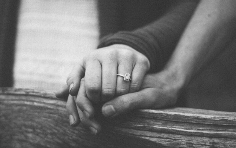 a couple holding hands with a wedding ring visible