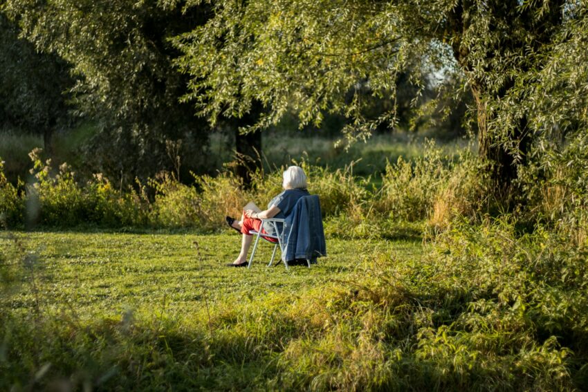 a woman sitting on a chair in a field