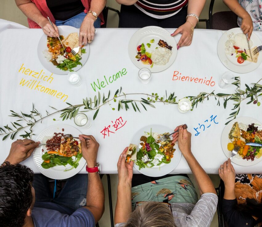 A group of people sitting around a table with plates of food