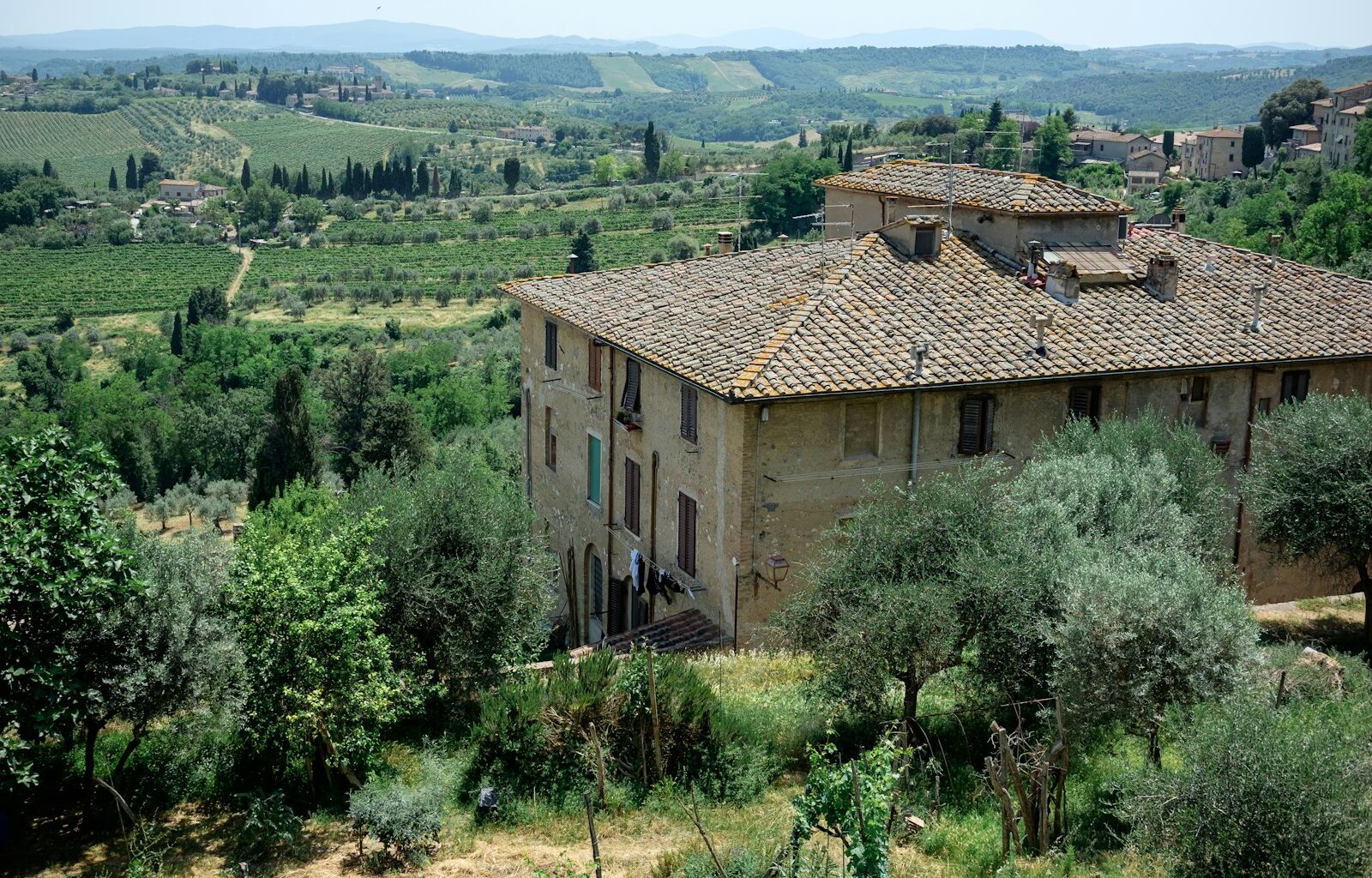 an old building surrounded by trees and hills