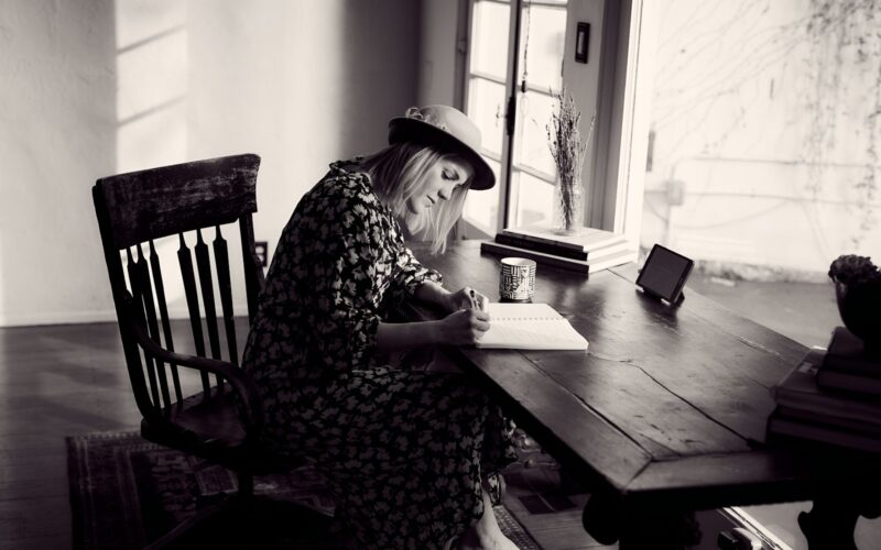 woman in black and white floral dress sitting on chair