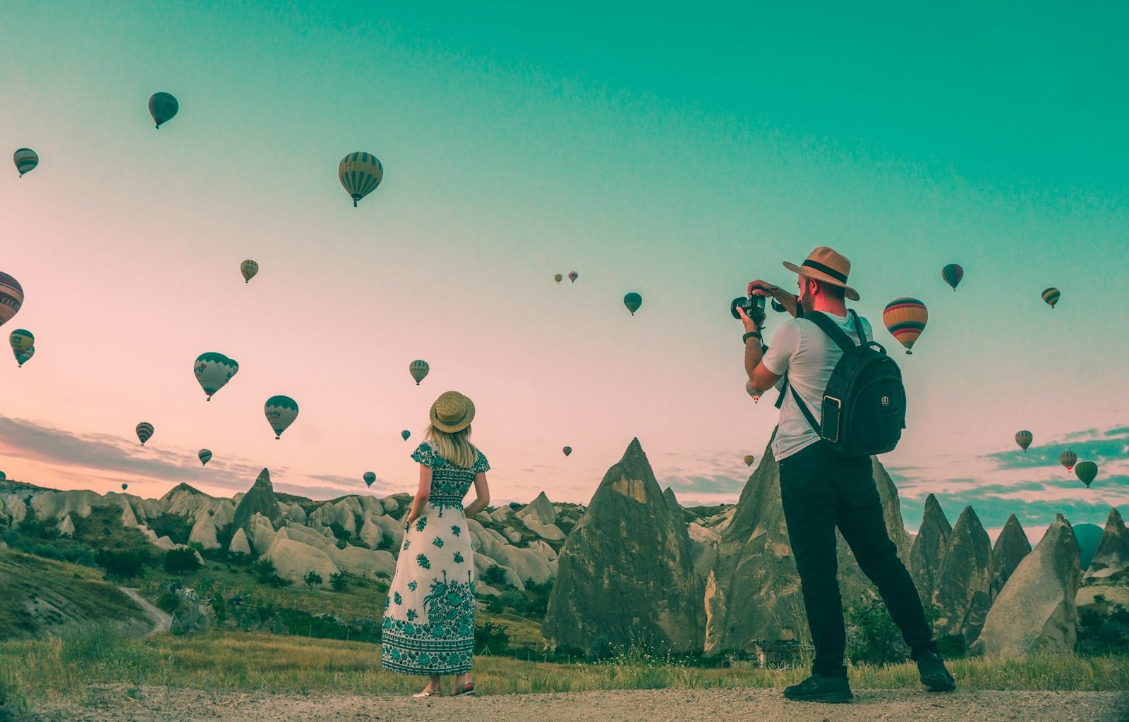 man taking photo of hot air balloons