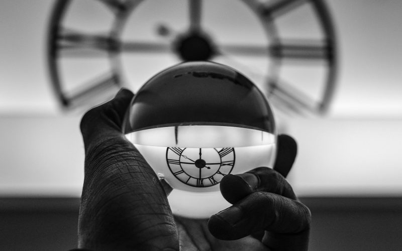 grayscale photography of person holding glass ball