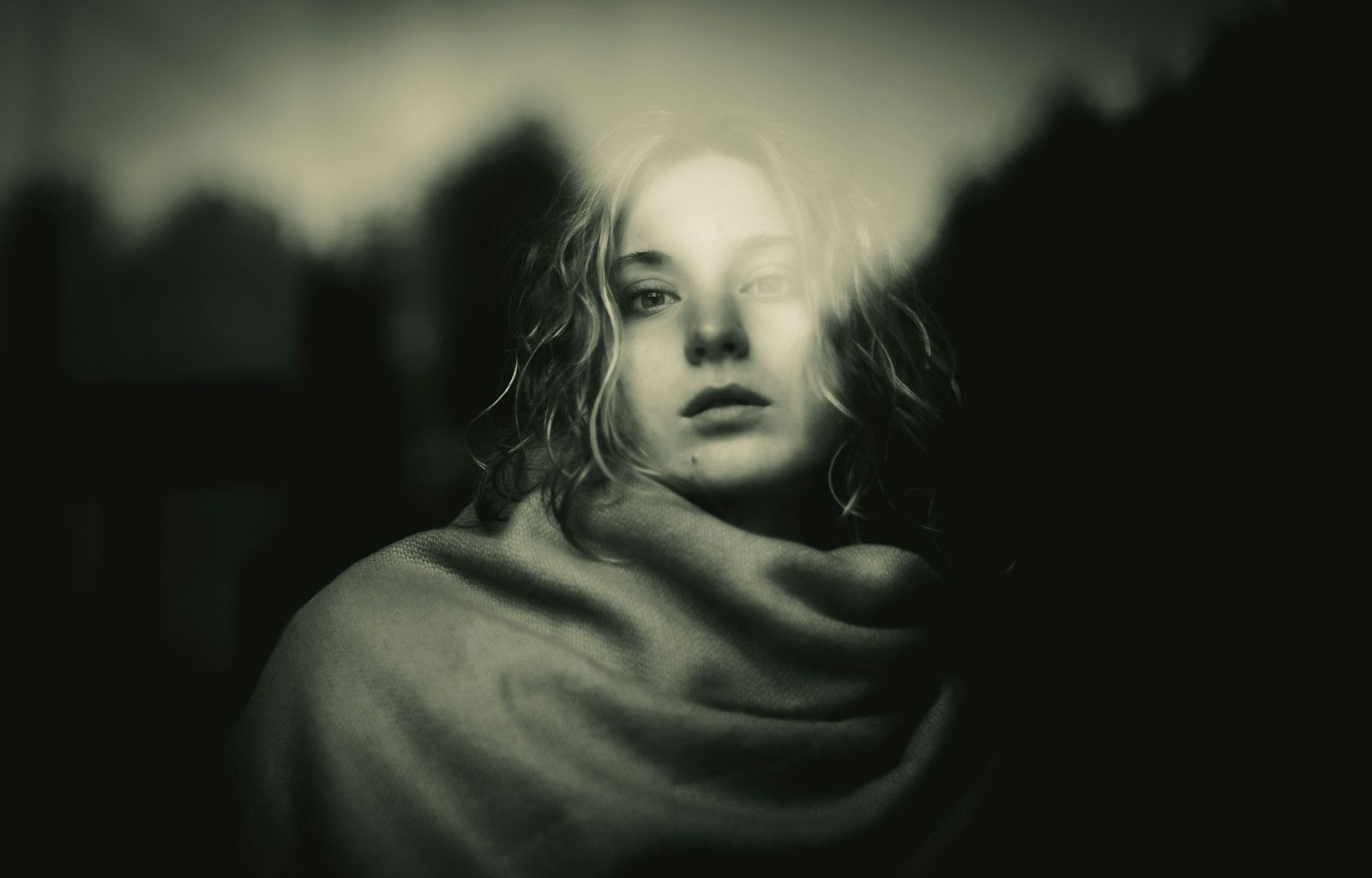 A black and white photo of a woman wrapped in a blanket