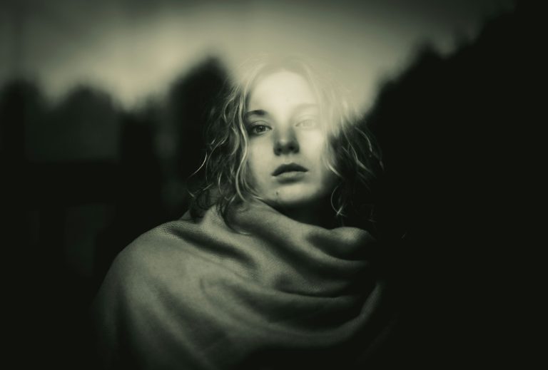 A black and white photo of a woman wrapped in a blanket