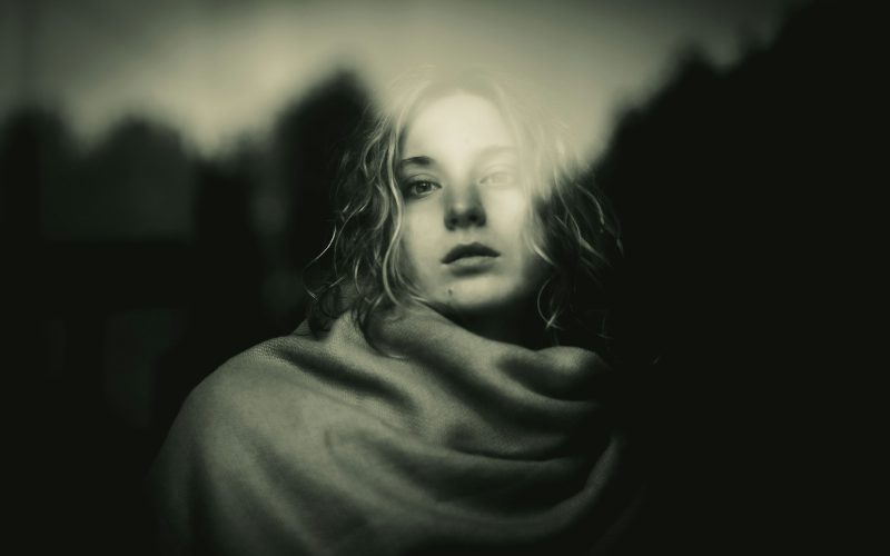 A black and white photo of a woman wrapped in a blanket