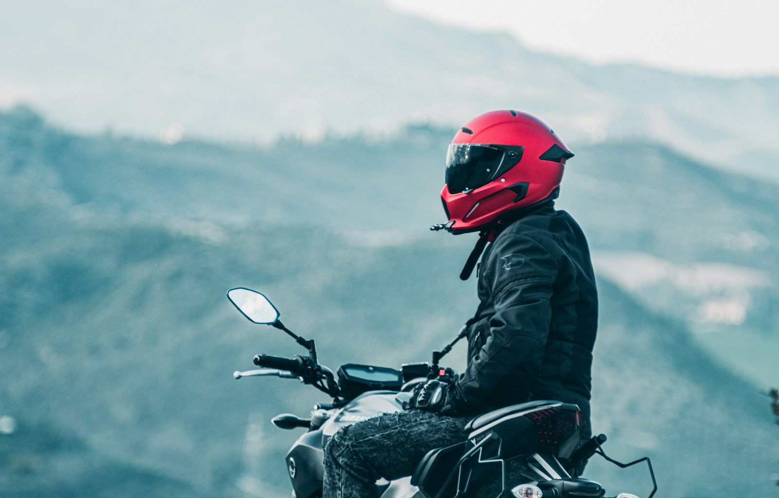 a man riding a motorcycle with a mountain in the background