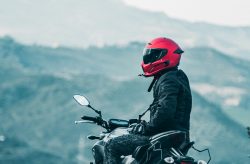 a man riding a motorcycle with a mountain in the background