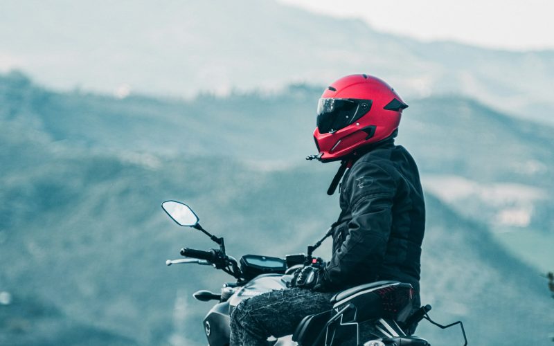 a man riding a motorcycle with a mountain in the background